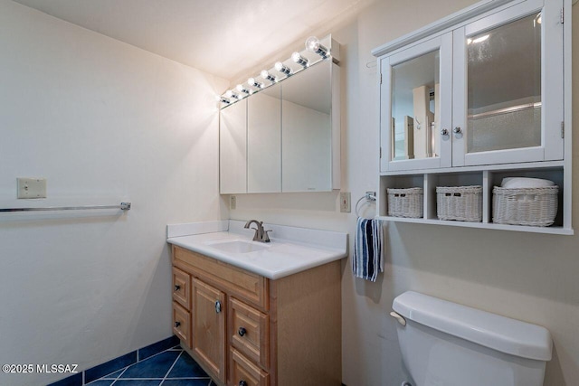 half bathroom with toilet, tile patterned flooring, and vanity