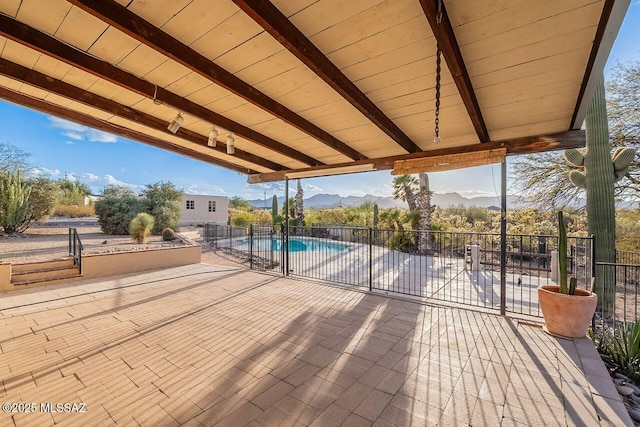 view of patio / terrace with fence, a mountain view, and a fenced in pool