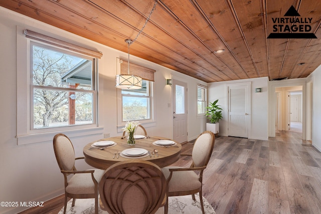 dining room with wooden ceiling, wood finished floors, and baseboards