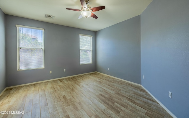 empty room with ceiling fan and light hardwood / wood-style floors