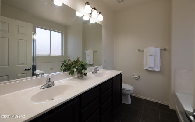 bathroom with a bathing tub, vanity, toilet, and tile patterned floors