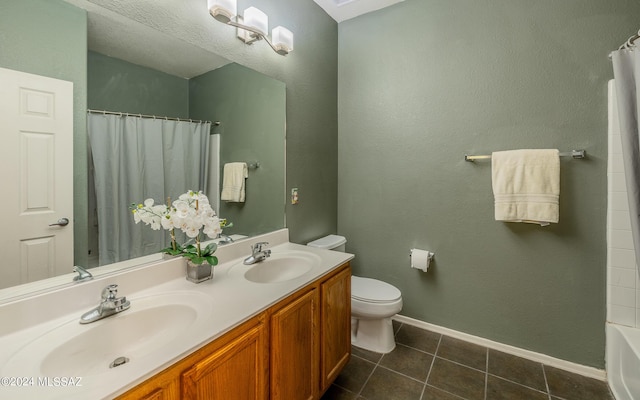 bathroom featuring toilet, a textured ceiling, vanity, and tile patterned floors