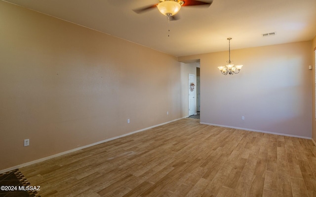 unfurnished room with wood-type flooring and ceiling fan with notable chandelier