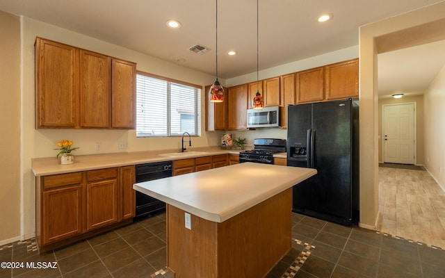 kitchen with sink, black appliances, dark tile patterned flooring, a kitchen island, and hanging light fixtures