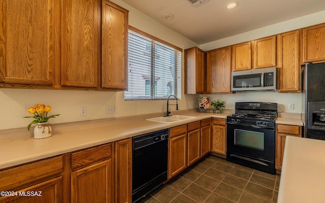 kitchen with sink, black appliances, and dark tile patterned flooring