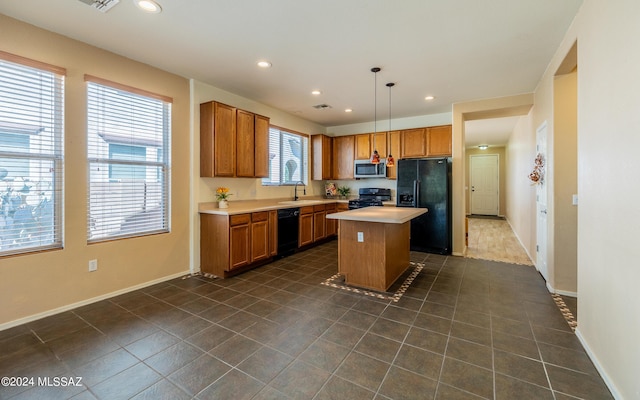 kitchen featuring sink, black appliances, decorative light fixtures, dark tile patterned flooring, and a center island