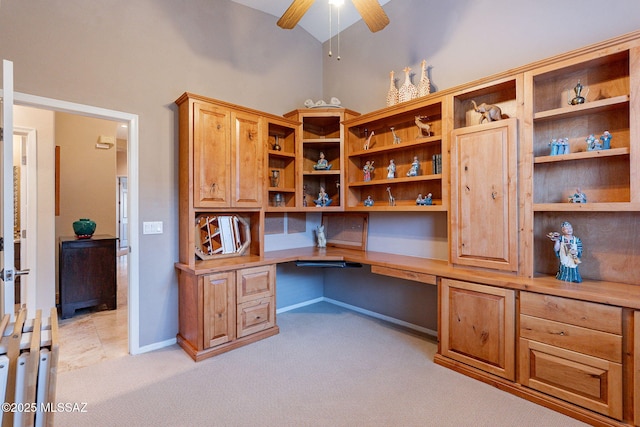 office space with light carpet, ceiling fan, built in desk, and high vaulted ceiling