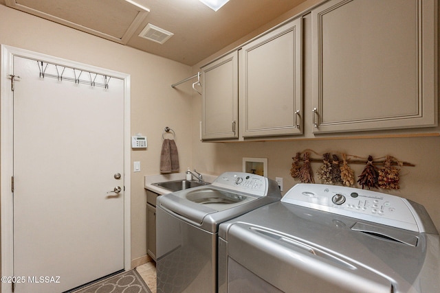 laundry room with cabinets, washing machine and dryer, and sink