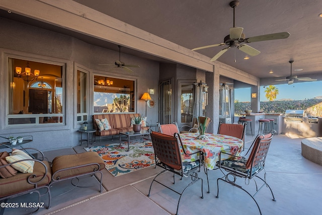 view of patio with ceiling fan, area for grilling, and exterior bar