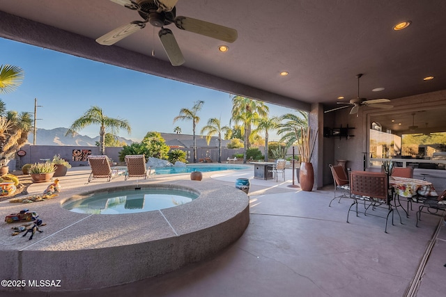 view of pool with a mountain view, a patio, an in ground hot tub, and ceiling fan