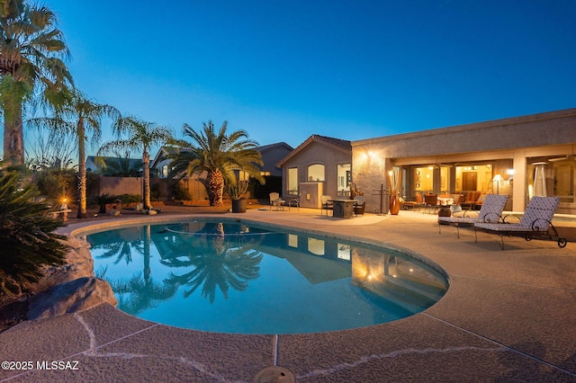 pool at dusk with a patio area