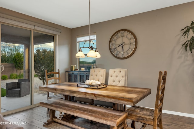 dining room with wood-type flooring and an inviting chandelier