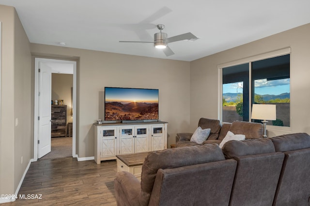 living room featuring ceiling fan and dark hardwood / wood-style flooring