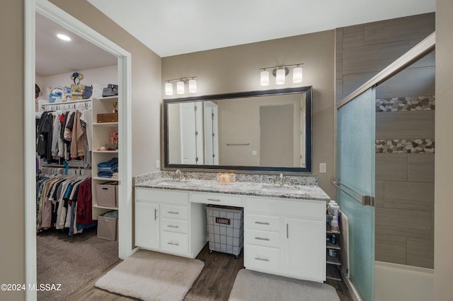 bathroom featuring hardwood / wood-style floors, vanity, and tiled shower