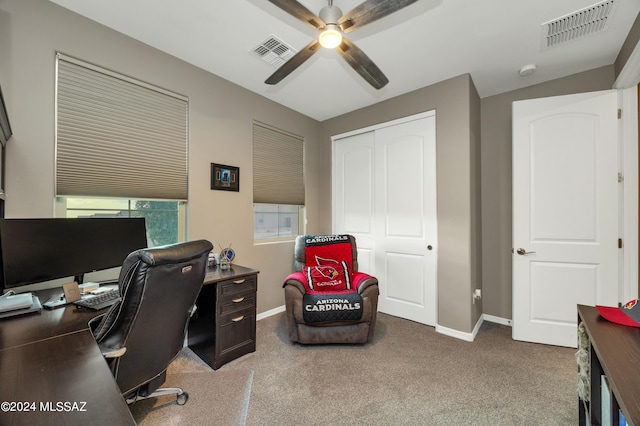 carpeted home office featuring ceiling fan