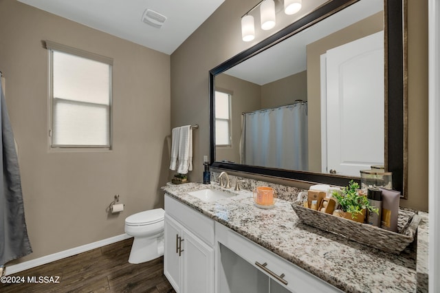 bathroom featuring wood-type flooring, vanity, and toilet