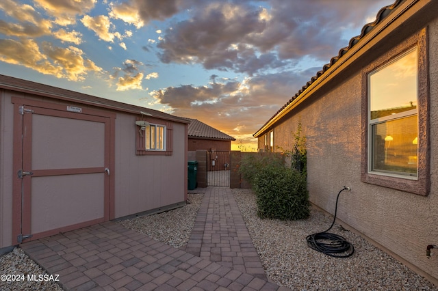 property exterior at dusk with a storage unit