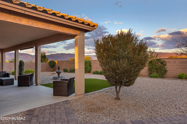 patio terrace at dusk featuring a mountain view