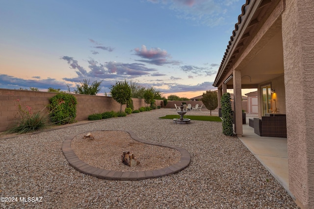 yard at dusk featuring a patio