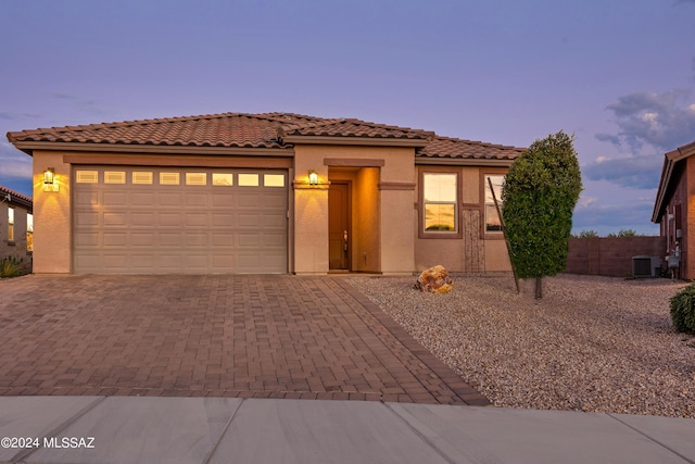 mediterranean / spanish-style home featuring a garage and cooling unit