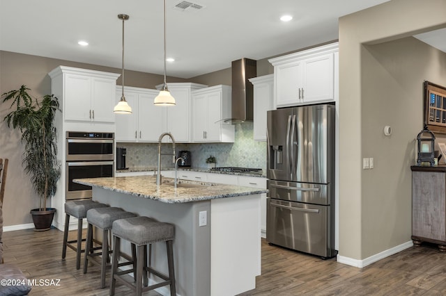 kitchen featuring white cabinets, sink, wall chimney exhaust hood, and appliances with stainless steel finishes