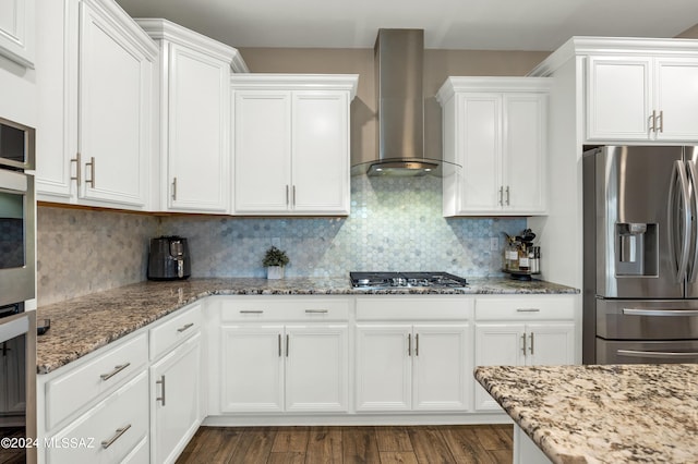 kitchen featuring tasteful backsplash, white cabinets, wall chimney exhaust hood, and stainless steel appliances