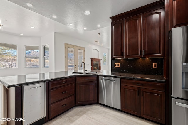 kitchen featuring kitchen peninsula, sink, a healthy amount of sunlight, and appliances with stainless steel finishes