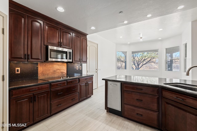 kitchen with dark brown cabinets, black electric cooktop, sink, and tasteful backsplash