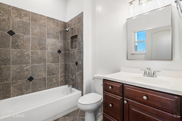 full bathroom with tile patterned floors, vanity, tiled shower / bath combo, and toilet