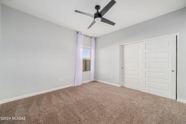 unfurnished bedroom with ceiling fan, carpet floors, and a closet