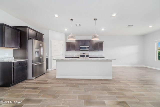 kitchen featuring appliances with stainless steel finishes, dark brown cabinets, light stone counters, and hanging light fixtures