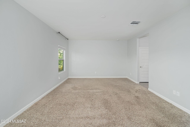 spare room featuring light carpet