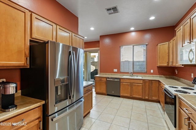 kitchen with light tile patterned flooring, appliances with stainless steel finishes, and sink