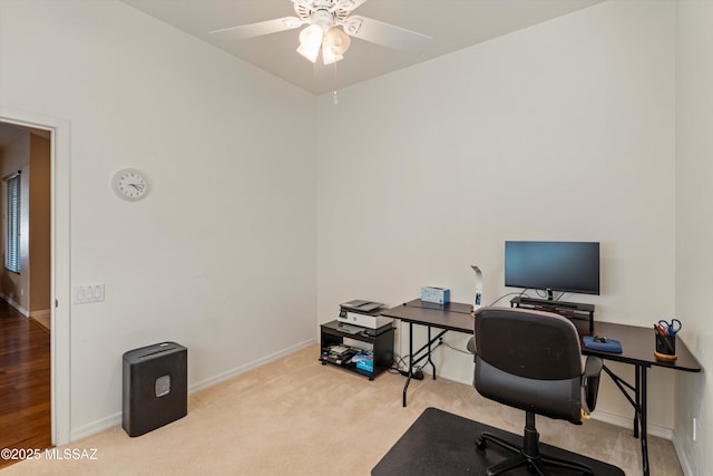 carpeted home office featuring ceiling fan