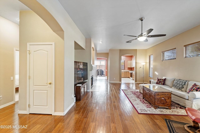 living room featuring ceiling fan and light hardwood / wood-style floors