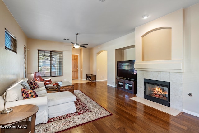 living room featuring hardwood / wood-style floors, a fireplace, and ceiling fan