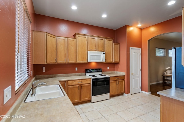 kitchen with fridge, sink, light tile patterned floors, and electric range