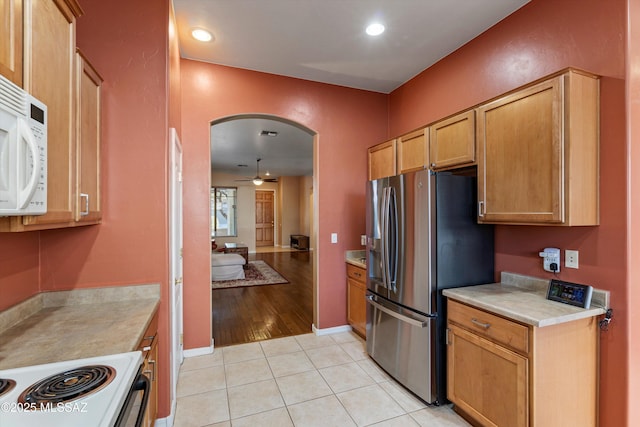 kitchen with light tile patterned floors, white appliances, and ceiling fan