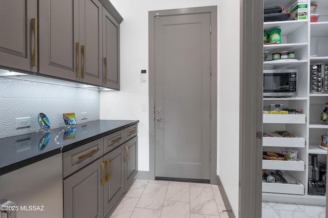 interior space featuring tasteful backsplash and gray cabinetry