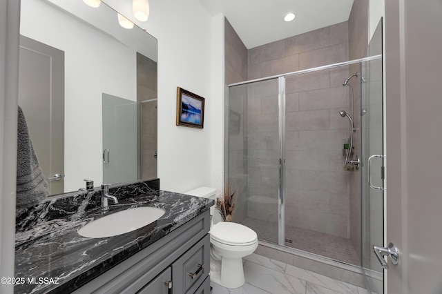 bathroom featuring toilet, a shower with door, and vanity