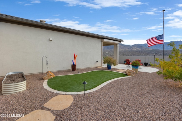 view of yard featuring a mountain view and a patio