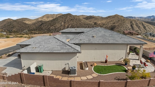 back of property with central AC and a mountain view