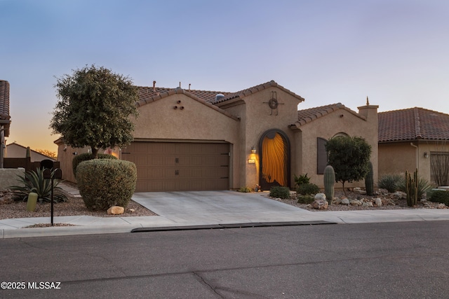 mediterranean / spanish-style home with a garage