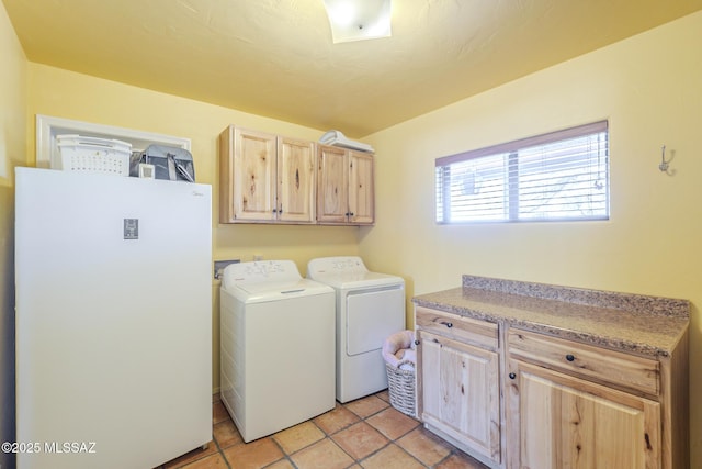 washroom featuring washer and dryer, cabinets, and light tile patterned flooring