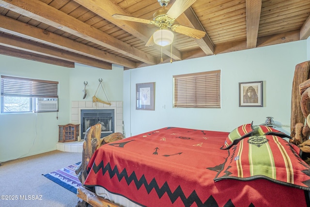 carpeted bedroom with wooden ceiling, a tile fireplace, ceiling fan, cooling unit, and beam ceiling