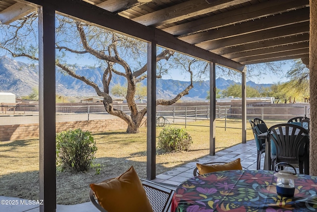 sunroom featuring wooden ceiling, beamed ceiling, and a mountain view