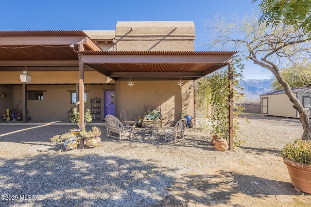 view of front facade with a patio, a storage unit, and a mountain view