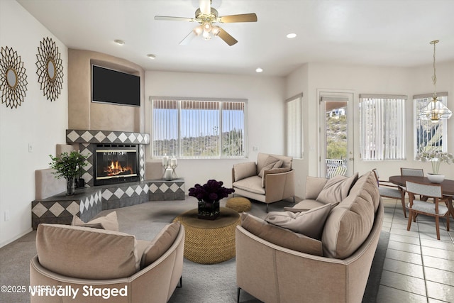 living room with ceiling fan, a fireplace, and tile patterned floors