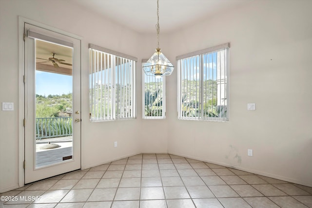 unfurnished dining area featuring ceiling fan and light tile patterned floors