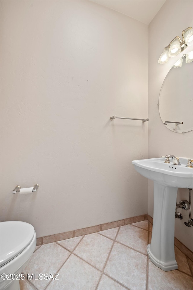 bathroom featuring toilet and tile patterned flooring